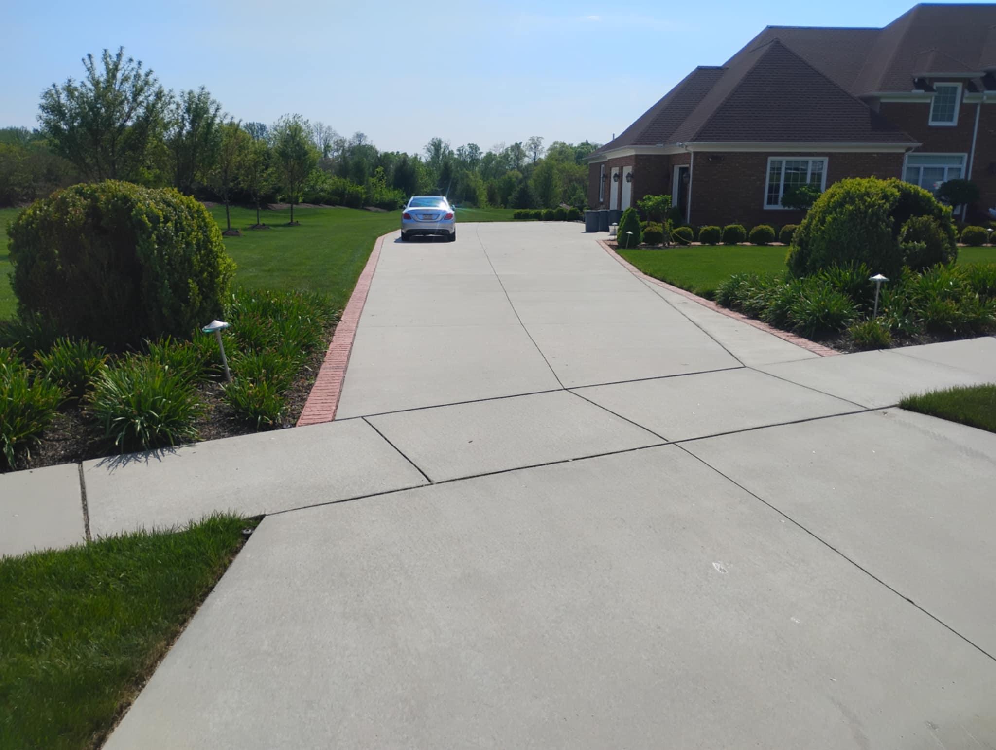 Elegant concrete driveway with decorative brick borders installed by Rhinesmith Masonry